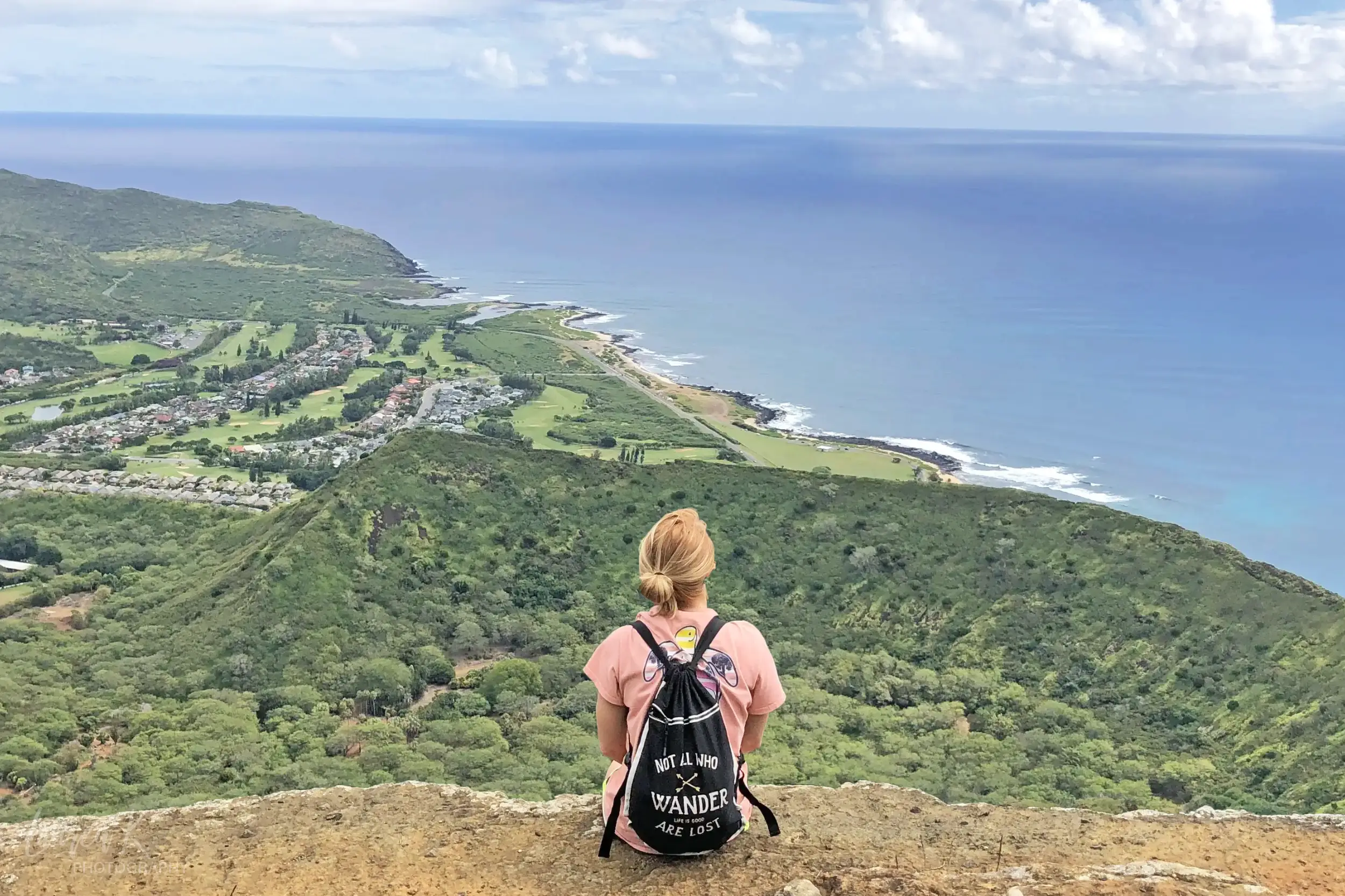 Lauren Edmondson of Inspired Backpacker on a cliff overlooking Oahu Hawaii, as a solo traveler