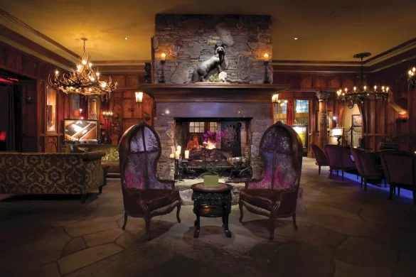 A dimly lit lobby of the Grand Bohemian Hotel in Asheville with chandeliers and eclectic furniture, to show its one of the best places to stay in the city for speakeasy lovers