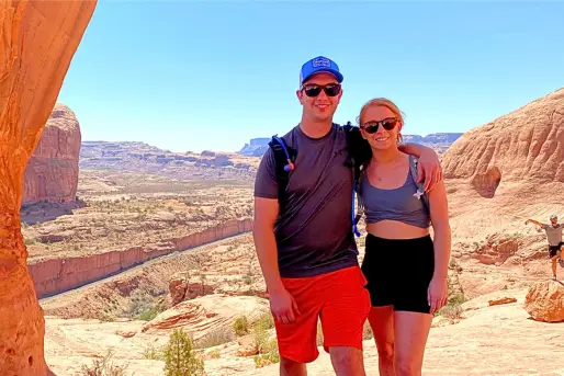 Couple hiking and posing for a photo at Arches National Park
