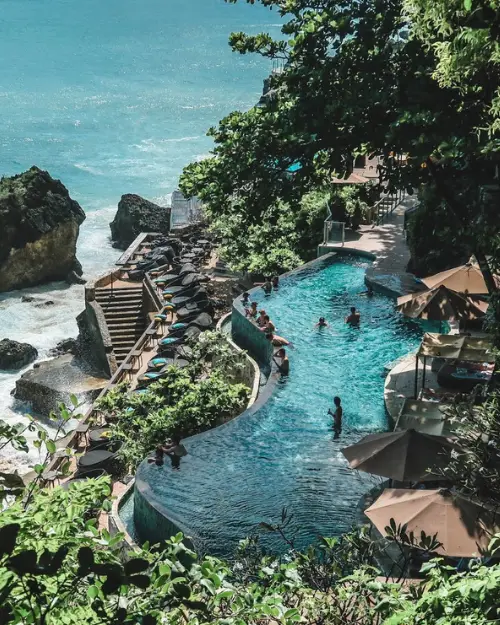 The infinity pool overlooking cliffs and ocean at Ayana resort in Uluwatu Bali 