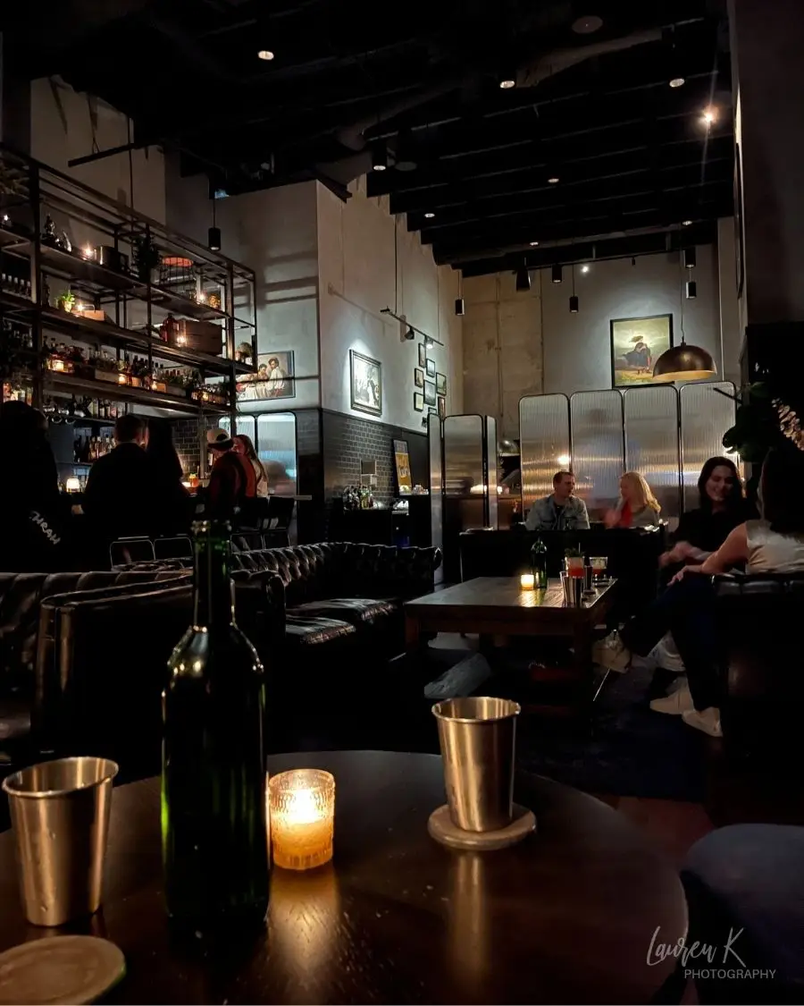Dimly lit bar with high ceilings and candles throughout