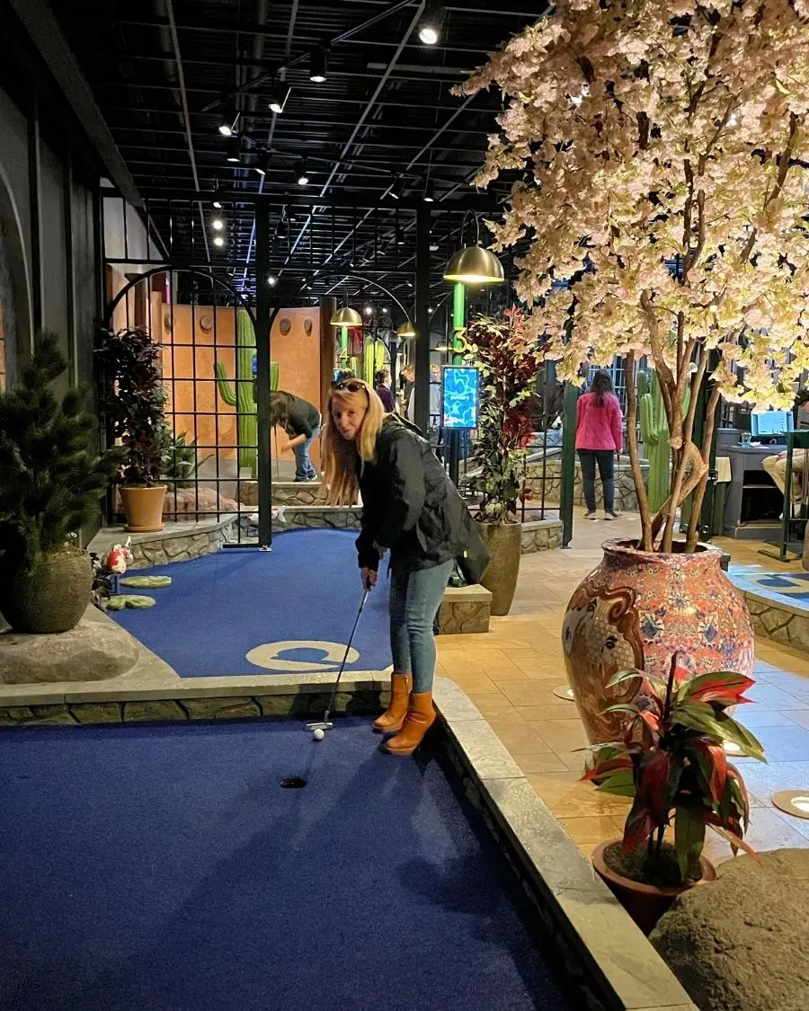 Woman about to hit her ball at the Puttery in Charlotte NC mini golf