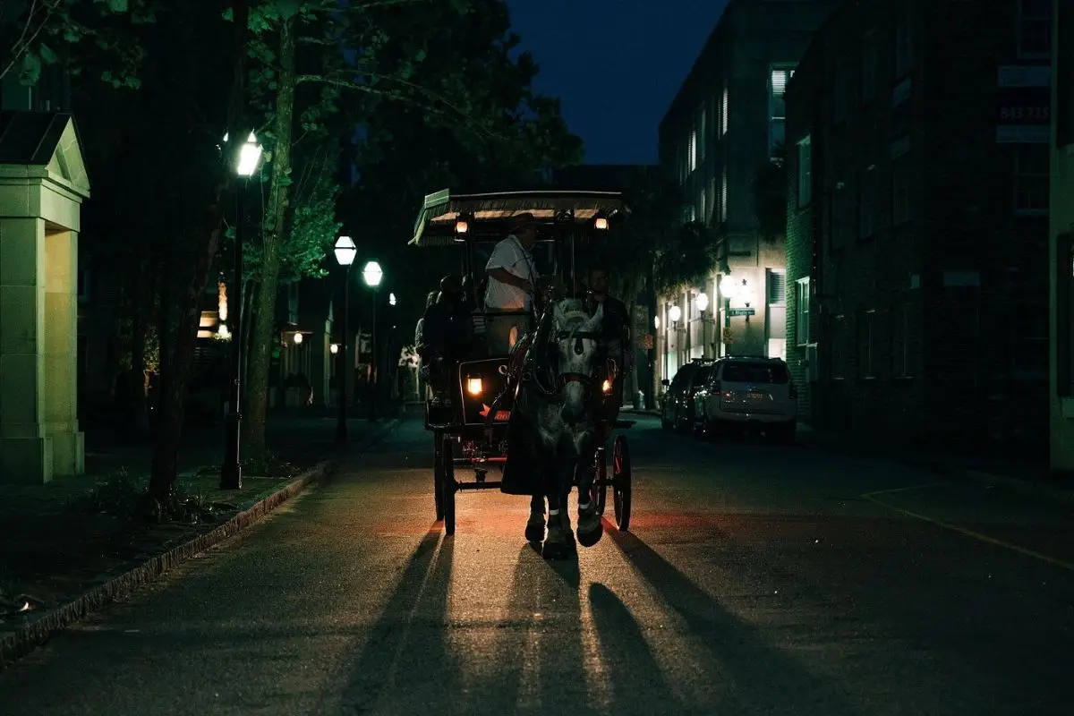 A spooky horse drawn carriage on a dark back street in Charleston, showing that this tour is one of the best things to do in Charleston for people who love spooky sights