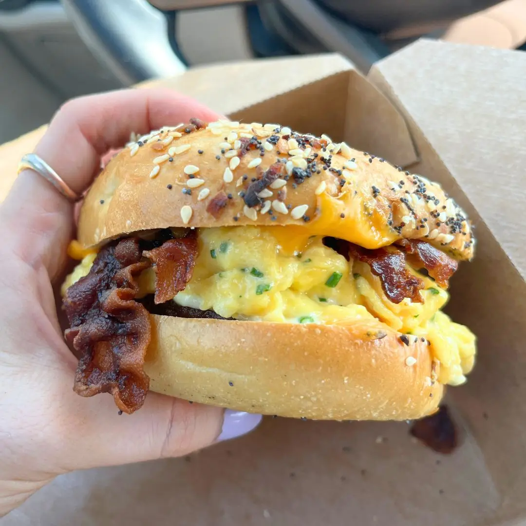 A delicious looking bacon, egg and cheese sandwich on a bagel from Dead Low Cafe in my hands