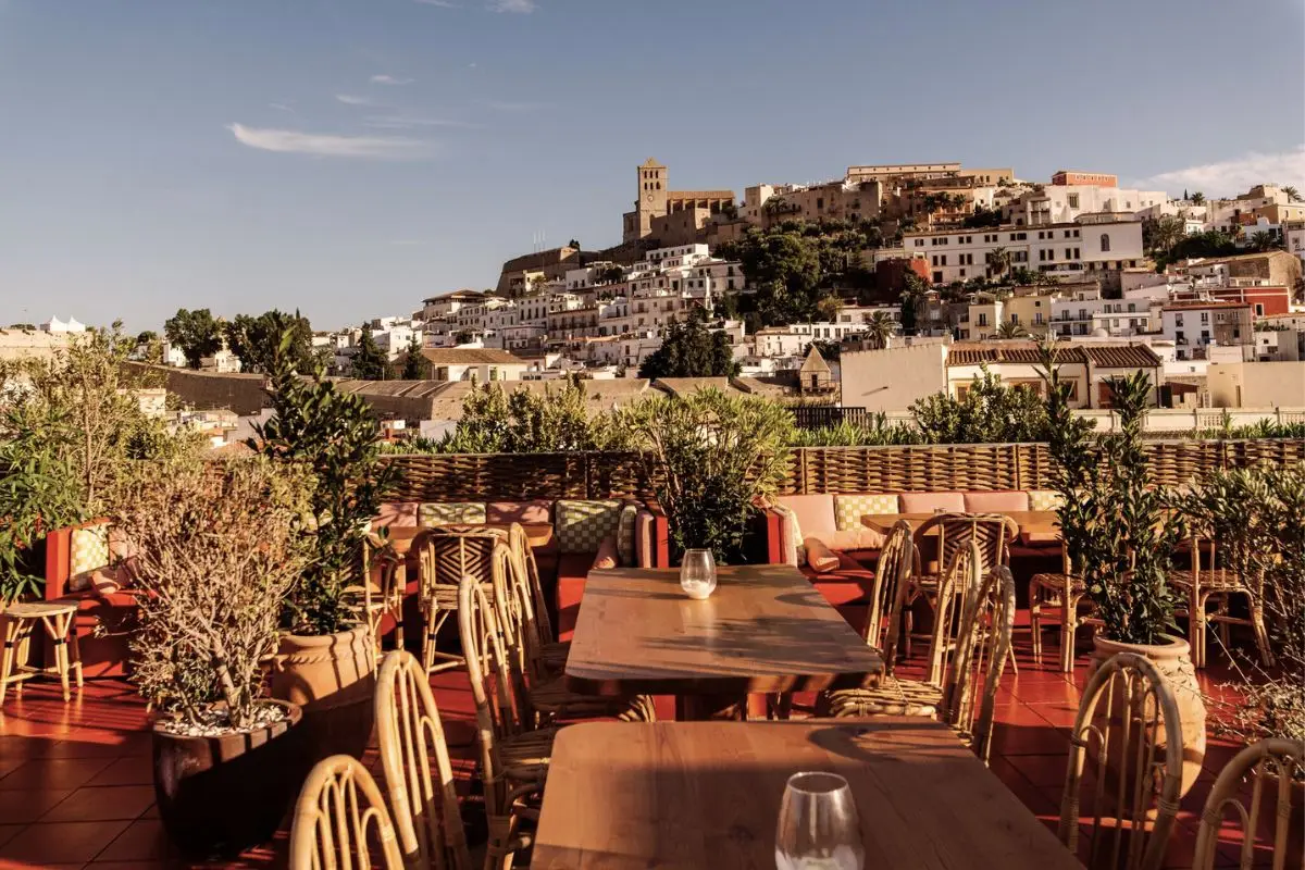 Chairs and tables on the Hotel Montesol rooftop bar, overlooking Dalt Vila and Old Town Ibiza in the afternoon