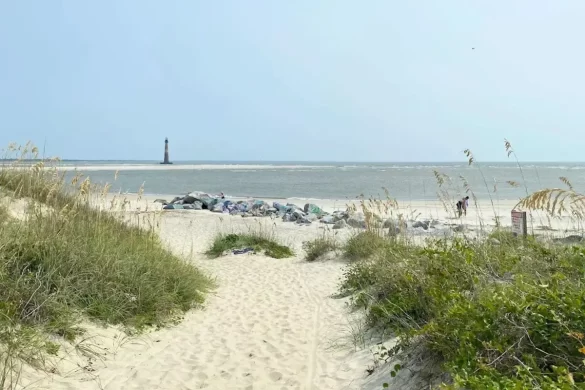 The Morris Island lighthouse beyond an inlet in the distance on a clear sky day