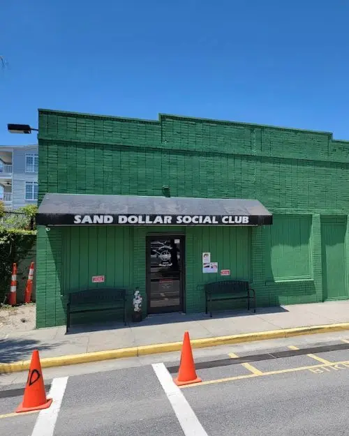 The green exteiror of Sand Dollar Social Club