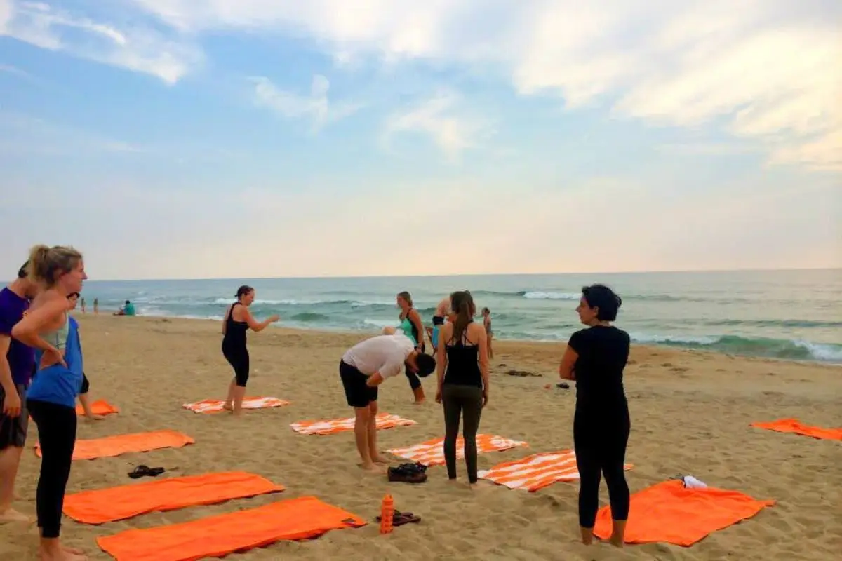 Some people with orange towels about to do yoga on the beach in the morning at the Sanderling