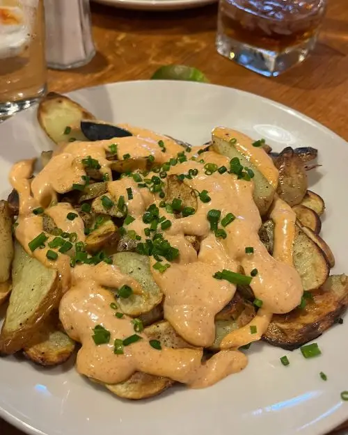 A potatoes appetizer at Bella Luna in Harrisonburg, which resembles potatoes bravas in Spain with orange spicy sauce on top