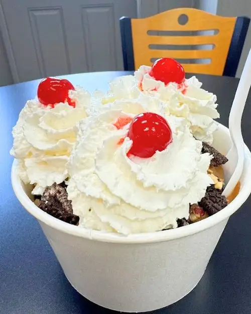 Cup of ice cream with whipped cream and cherries on top at Leo's Homemade