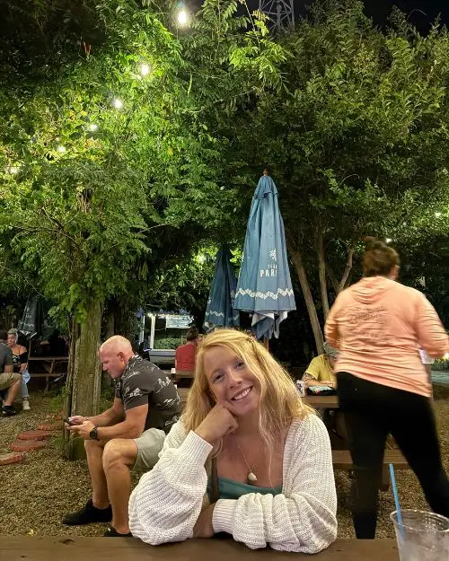 Me sitting and smiling at a picnic table at the Outer Banks Brewing Station