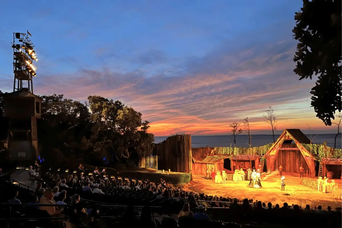 The Lost Colony show, one of the best things to do in Outer Banks NC for families, going on in an outdoor theatre under a sunsetting sky with the water in the background