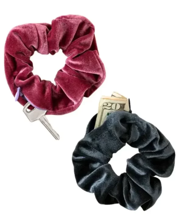 Two velvet scrunchies with hidden pockets, which you can see because cash and keys are popping out of them