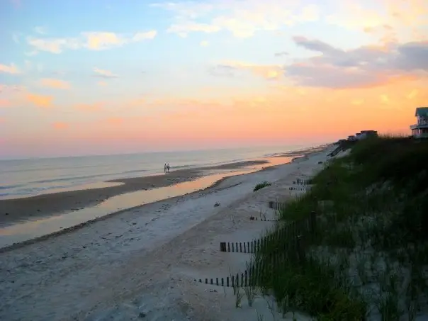 Sunset over the beach at Topsail Beach with the sunset reflecting on the ocean and dunes on the side