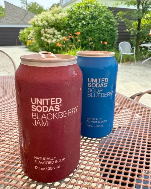 Two United sodas on a shaded table