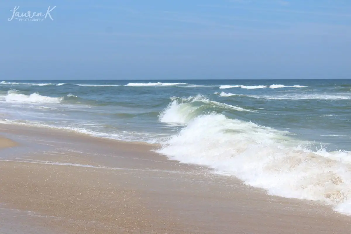 Cover image for the where to stay in Outer Banks blog, which is a photo of the ocean waves at Nags Head taken by Lauren of Inspired Backpacker