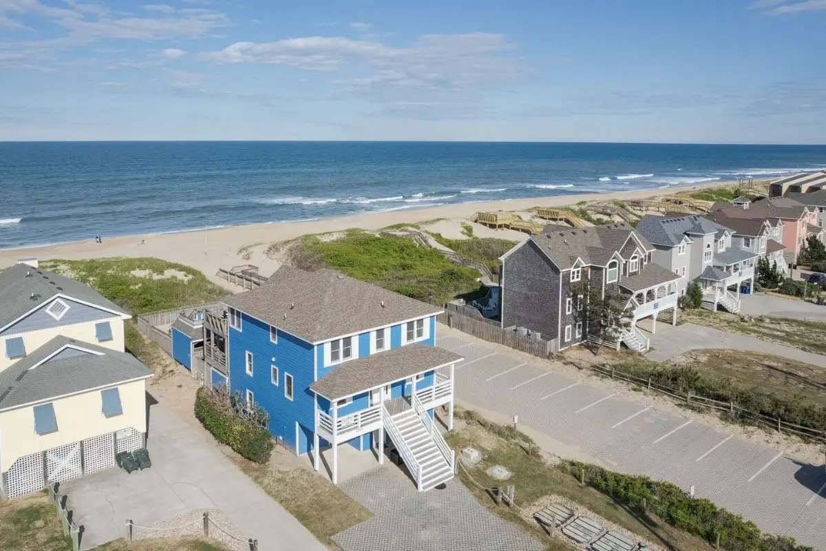 A row of vacation homes on the oceanfront on a sunny day to show that when choosing where to stay in Outer Banks NC, there are plenty of vacation homes to choose from