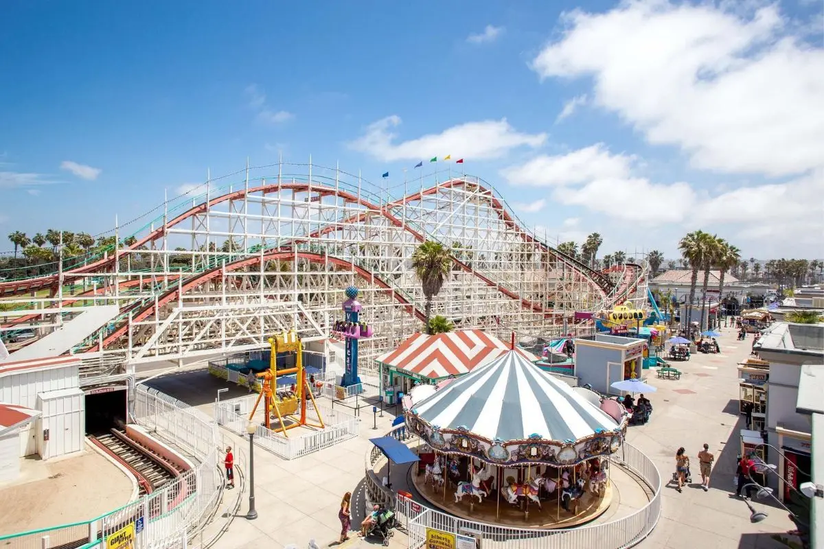 The giant dipper rollercoaster and carousel rides at Belmont Park on a sunny day