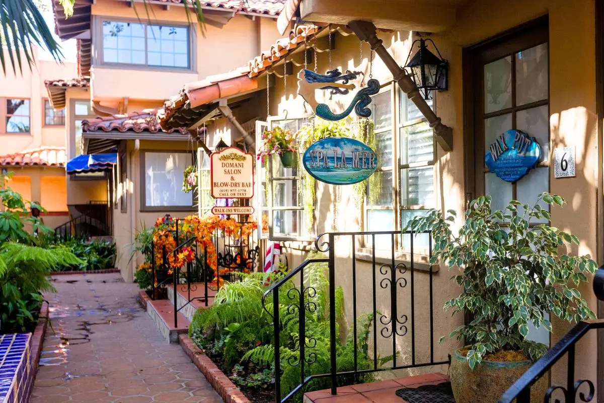 European style shop fronts with sun shining through the trees in an alley way
