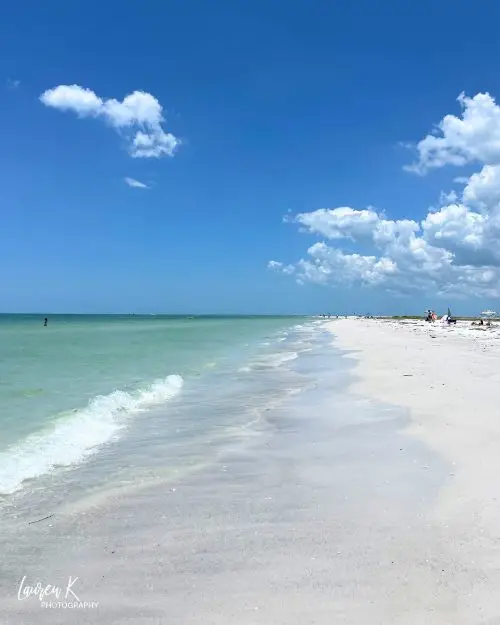 The clear aqua ocean rolling up along the white sand at an empty Fort de Soto Beach 
