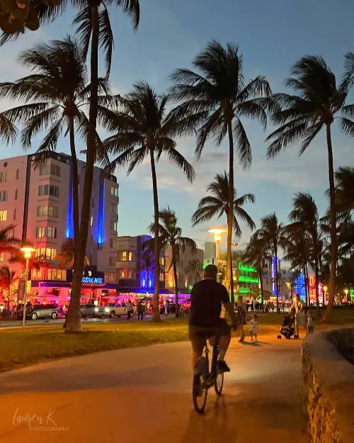 A man biking on the boardwalk in the Art Deco district of Miami Beach, to show its one of the best beach towns in Florida for nightlife and culture