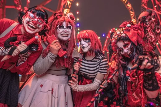 A group of four performers dressed up like red, scary clowns ready to haunt
