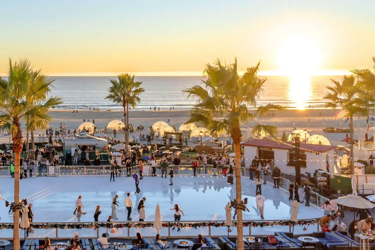 The oceanfront ice skating rink at the Hotel del Coronado with the sunsetting in the back, to display one of the most unique places to travel in December 