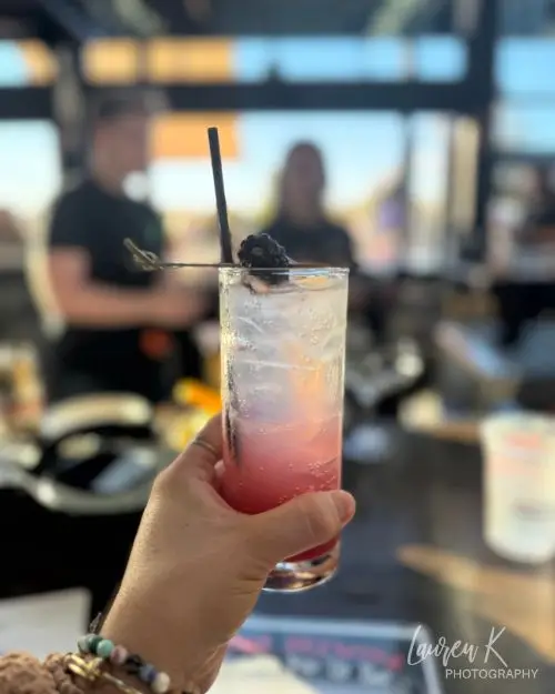 One of the cocktails at Honor Brewing in my hand with a blueberry on top