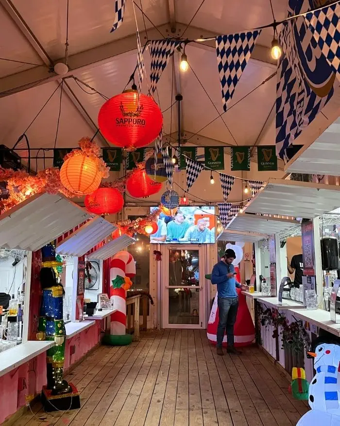 A rustic looking interior with food counters, flags hanging from the ceiling and lanterns