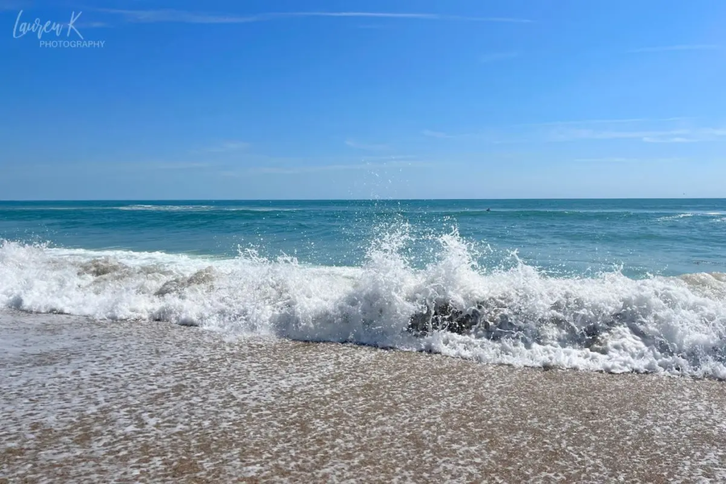Cover image for the best beaches in North Carolina blog, showing a wave crashing on the shore