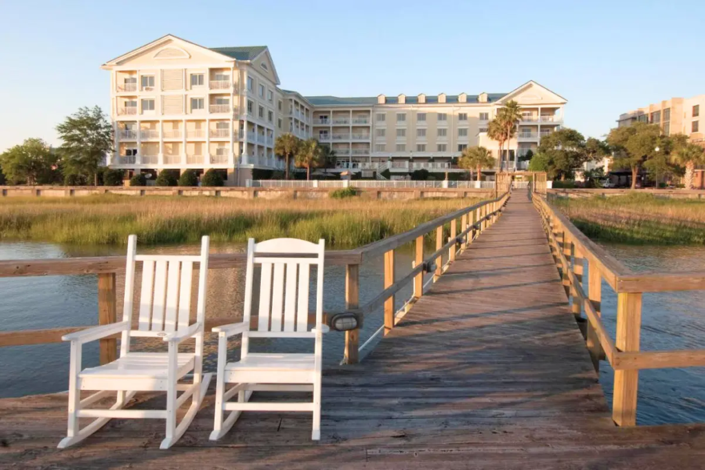 Two rocking chairs on a dock in front of a hotel, showing one of the beautiful places to stay for map of hotels in Charleston SC blog
