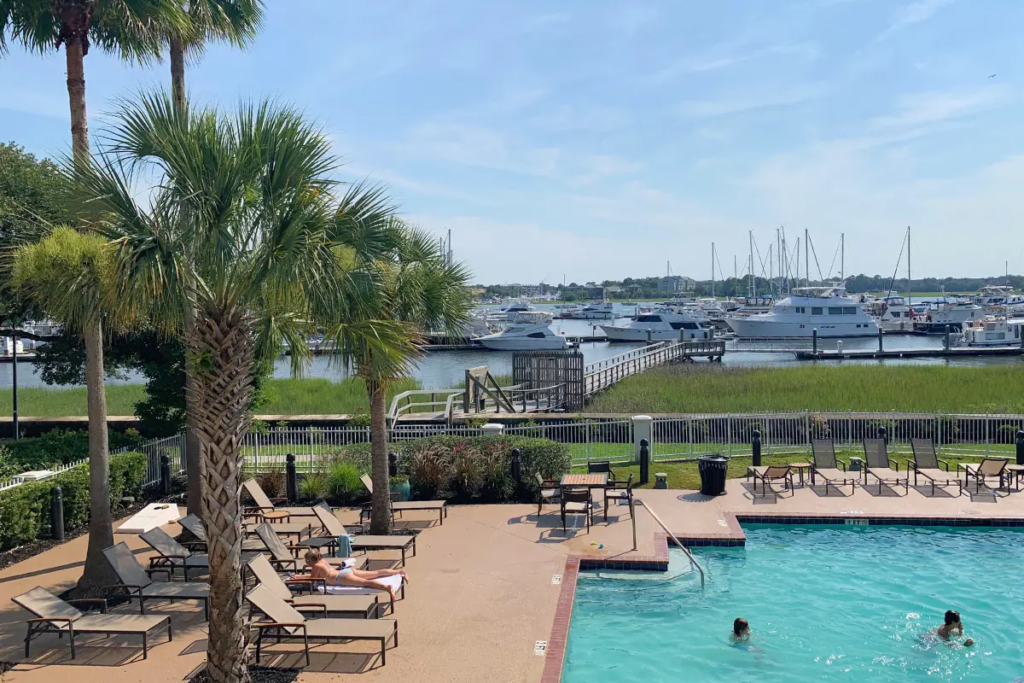 The pool overlooking the harbor at the Courtyard Charleston Waterfront Marriott with palm trees under a sunny sky