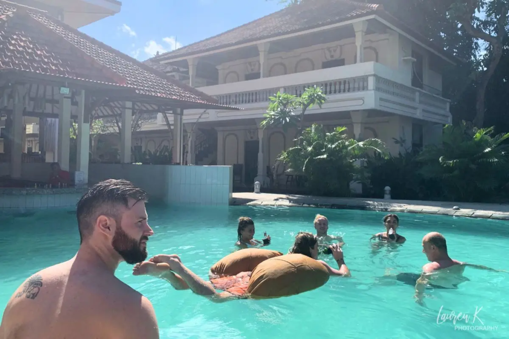 Cover image for the hostel tips blog which shows a big hostel pool in Kuta Bali