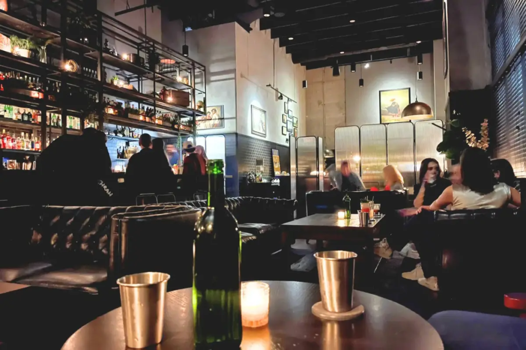 Cover image for the Idlewild Charlotte review which shows a dimly lit bar with candles and high ceilings
